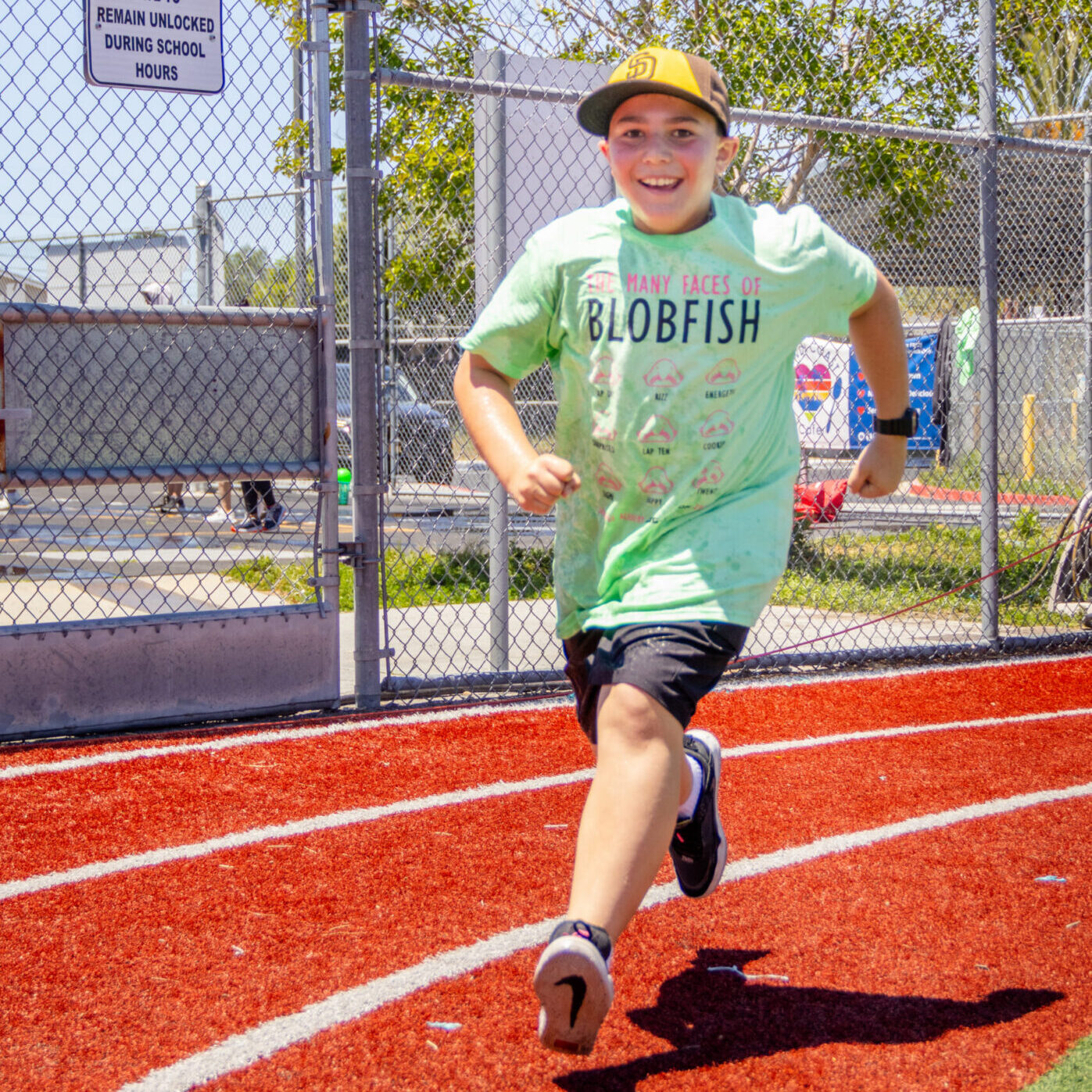 A boy runs around the track during jog-a-thon