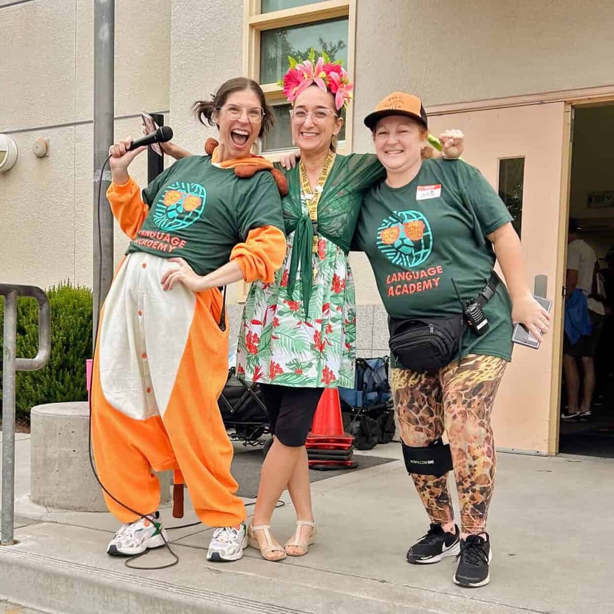Principal Cannon and Ms. Rodgers, and a parent pose together in front of the library during the jog-a-thon kick-off assembly.
